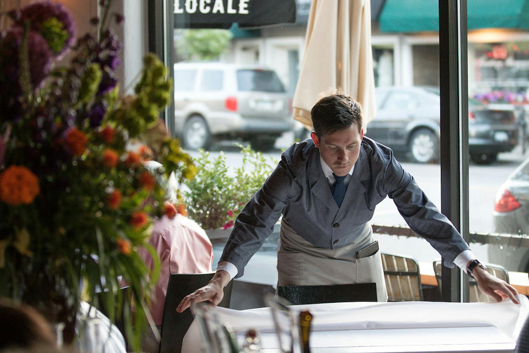 a waiter putting a tablecloth